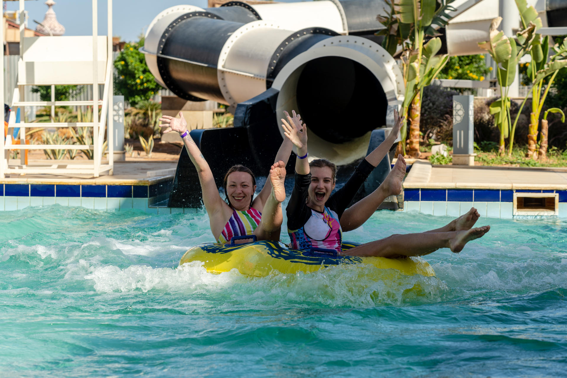 Happy women on water slide in aquapark. Having fun in aqua park